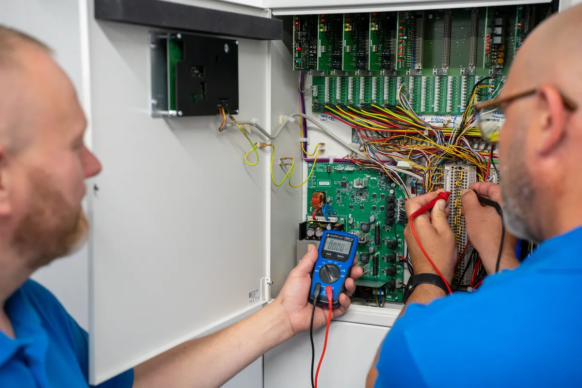 Zwei BAUM Techniker prüfen gemeinsam eine Alarmzentrale