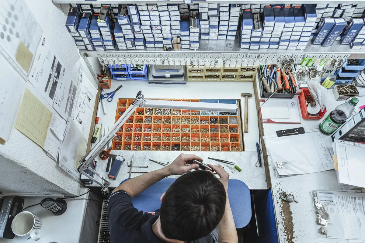 Werkbank mit Schlüsseln, Werkzeug und Teilen in der BAUM Werkstatt