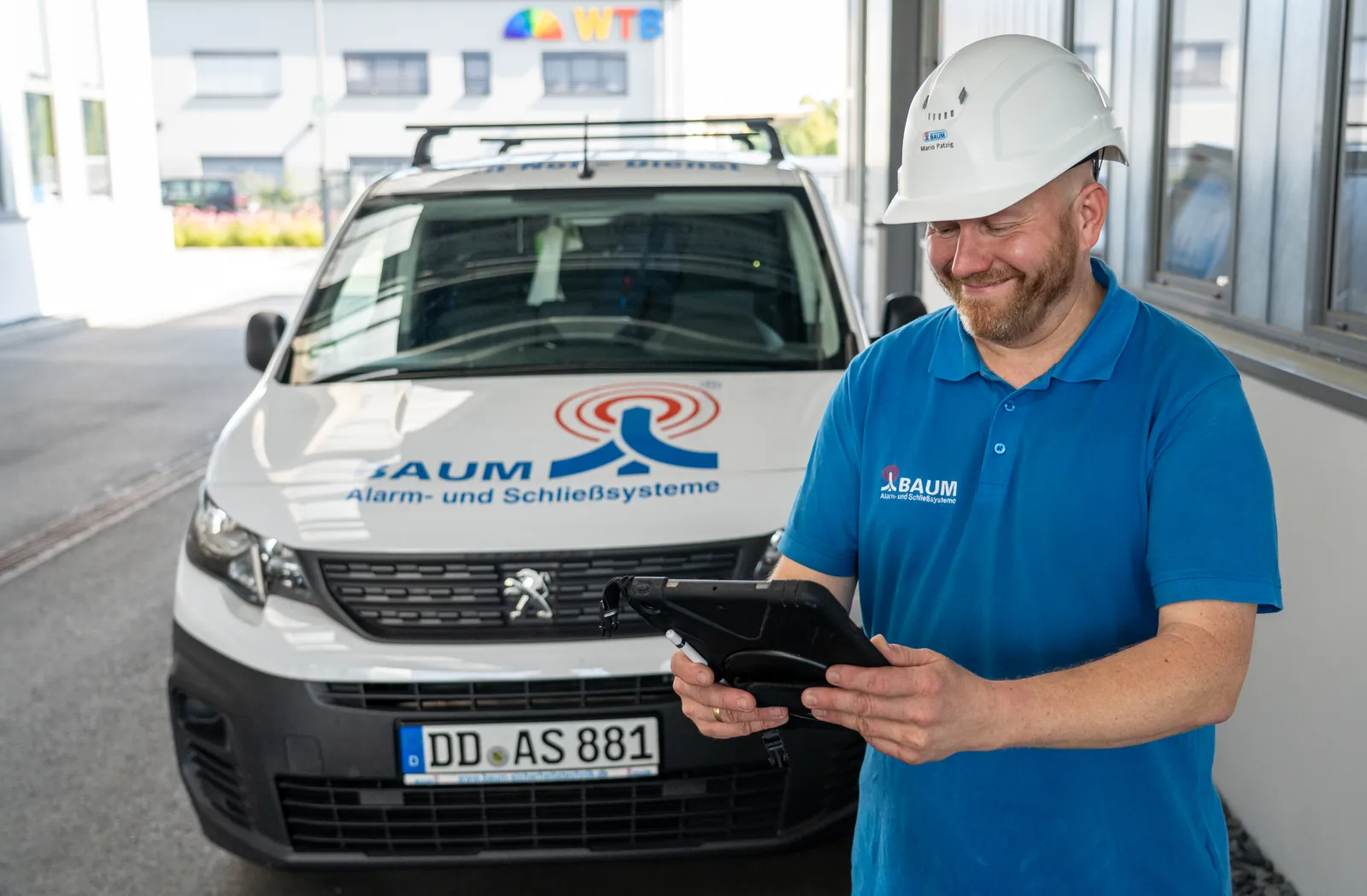 BAUM Techniker mit Tablet am Servicefahrzeug